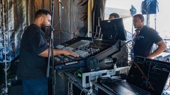 Sound engineers working on a Digico SD digital mixing console at a live event.